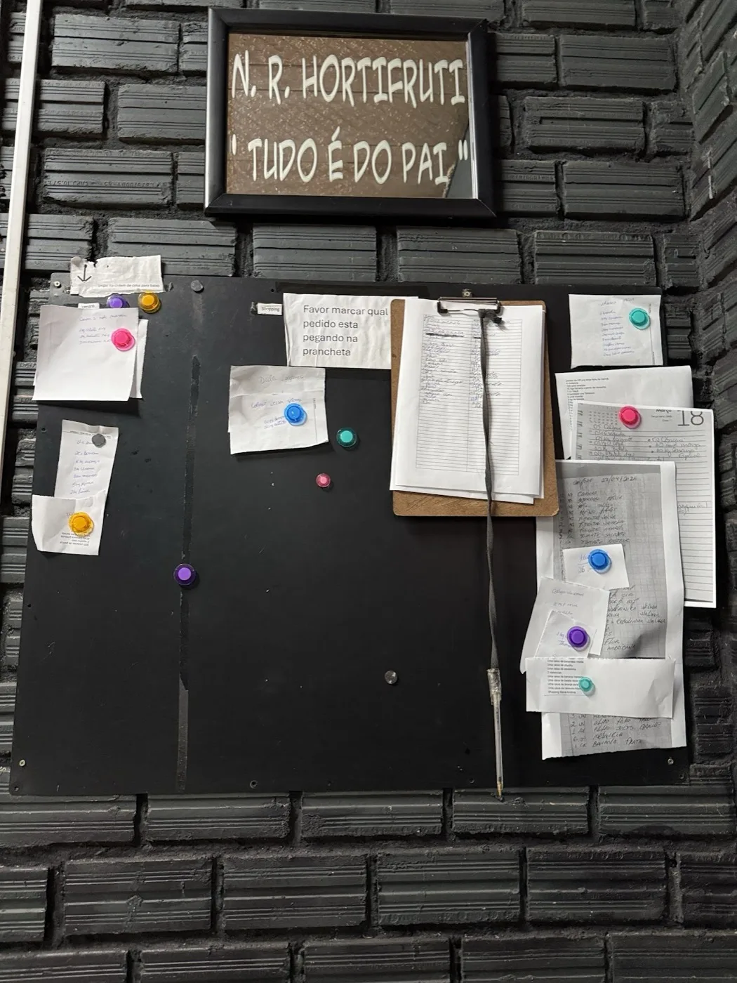Quadro de avisos do galpão com os pedidos em papel colados